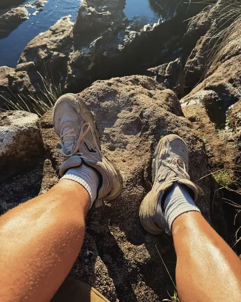 Sol Brah resting on a rock mid-hike in WYDE Soma shoes
